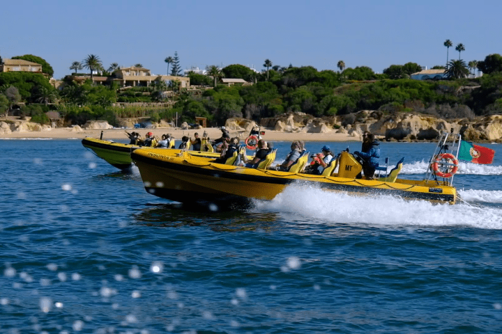 a group of people riding on the back of a boat in the water