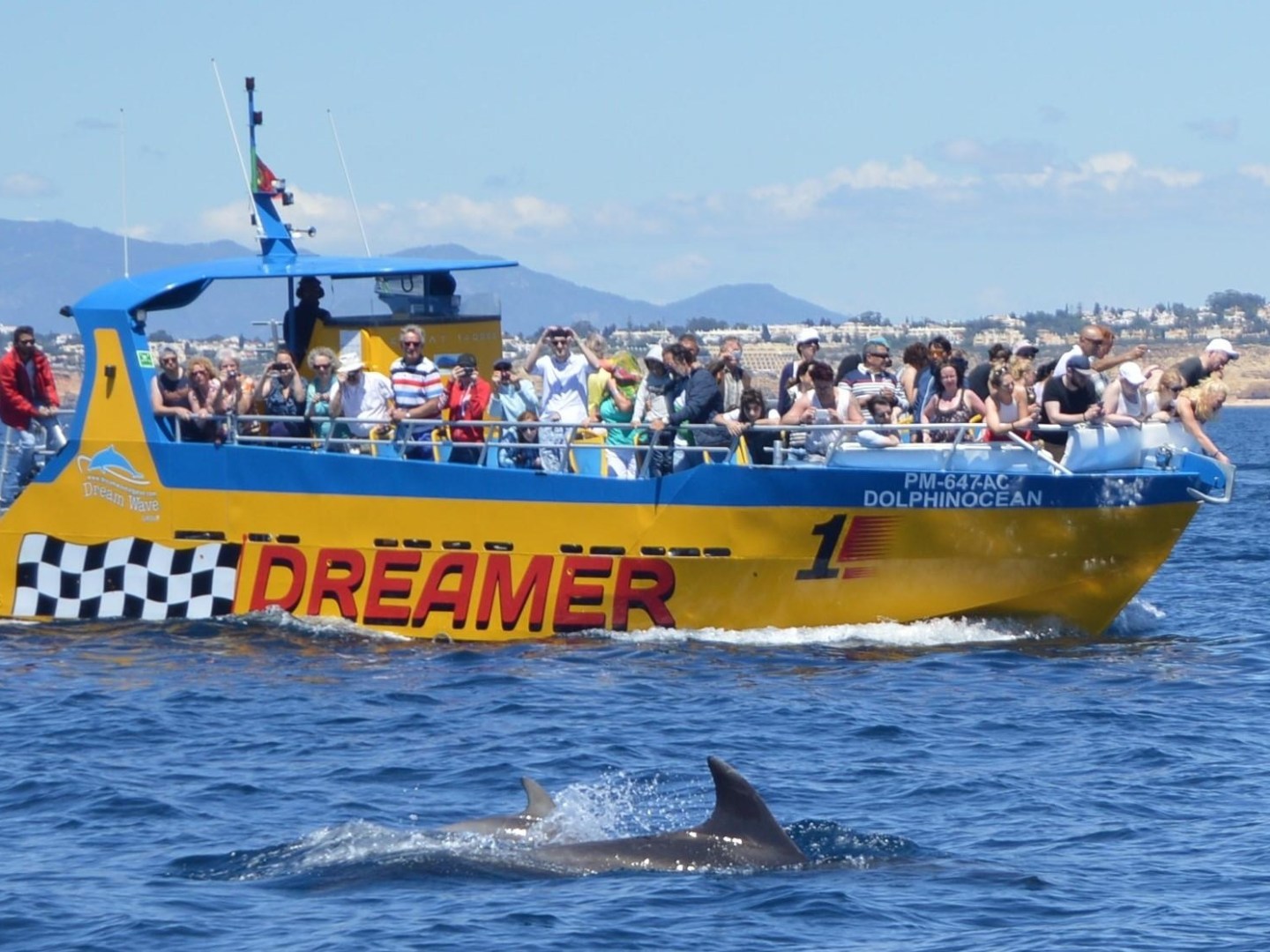a group of people riding on the back of a boat in the water